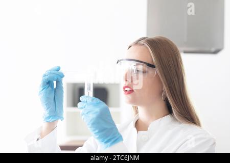 Junge Wissenschaftlerin mit langen Haaren und Laborbrille Stockfoto