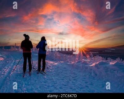 Wintersportler bei Sonnenuntergang auf dem Fichtelberg in sachsen, deutschland Stockfoto