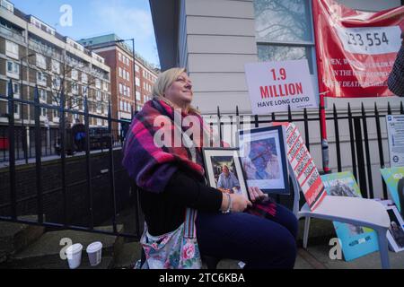 London Großbritannien. 11. Dezember 2023. Ein Verwandter hält Bilder des hinterlassenen Familienmitglieds, als Premierminister Rishi Sunak im covid-Untersuchungsmodul 2 Beweise gibt . Quelle: amer Gazzal/Alamy Live News. Stockfoto