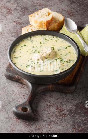 Rumänische Hühnersuppe namens Ciorba Radauteana aus der Nähe auf dem Teller auf dem Tisch. Vertikal Stockfoto