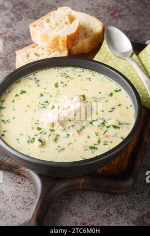 Ciorba radauteana rumänische traditionelle saure Hühnersuppe Nahaufnahme auf dem Teller auf dem Tisch. Vertikal Stockfoto