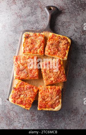 Traditionelle Sfincione- oder sizilianische Pizza mit hausgemachter Hefekruste und Tomatenzwiebelsauce, Käse und Sardellen in der Nähe des hölzernen B Stockfoto