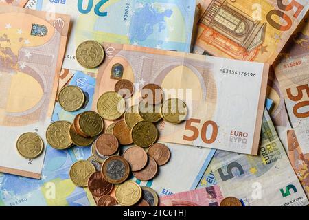 Euro-Banknoten und -Münzen auf dem Tisch als Hintergrund verstreut 18 Stockfoto