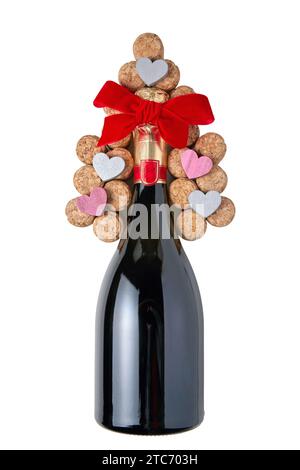 Flasche Sekt und Weinkorken in Form eines Weihnachtsbaums mit roter Schleife und Herzen auf weißem Hintergrund Stockfoto