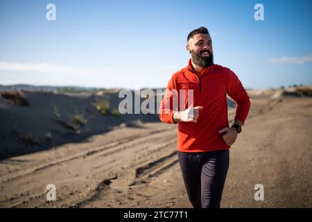 Erwachsener Mann joggt draußen an sonnigen Tagen. Stockfoto