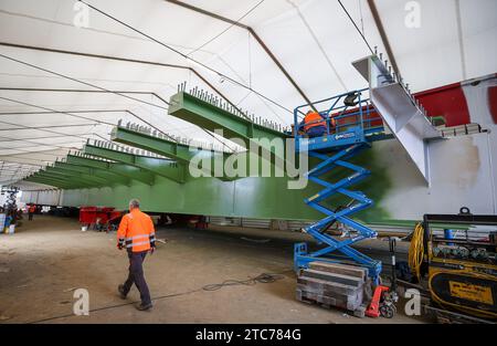 Grimma, Deutschland. Dezember 2023. Bauarbeiter bauen die Stahlkonstruktion der neuen Mulde-Brücke auf der A14. Am selben Tag soll das Straßenbauunternehmen DEGES die erste Verlagerung des südlichen Stahlaufbaus durchführen. Das Bauwerk ersetzt die alte Brücke aus den 1970er Jahren Die neue Brücke wird 361 Meter lang sein. Die Projektkosten in Höhe von 81 Millionen Euro werden vom Bund getragen. Die Umsetzung ist für 2027 geplant. Kredit: Jan Woitas/dpa/ZB/dpa/Alamy Live News Stockfoto