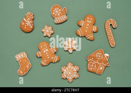 Weihnachtskekse auf grünem Pastell-Papier-Hintergrund. Lebkuchensammlung. Draufsicht, flach. Stockfoto