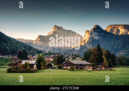 Wunderschöner Blick auf den Sonnenaufgang über die Bergkette mit hölzernem Chalet friedlichem Dorf auf einem Hügel in Sixt Fer a Cheval, Französische Alpen, Haute savoie, Frankreich Stockfoto