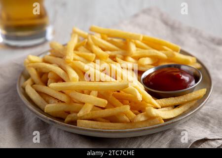 Hausgemachte Pommes Frites mit Ketchup und kaltem Bier, Blick aus dem niedrigen Winkel. Stockfoto