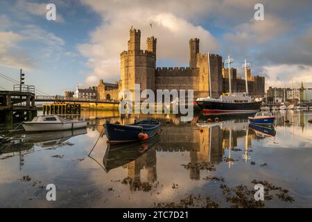 Caernarfon Castle spiegelt sich in den ruhigen Gewässern des Afon Seiont, Caernarfon, Nordwales, Großbritannien. Frühjahr (Mai) 2023. Stockfoto