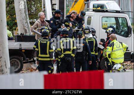 Klimaaktivisten, die mit Metallrohren an einen Kran gekettet sind, werden von der Nationalpolizei und der Feuerwehr während eines Protestes gegen das Fällen von Bäumen entfernt. Nachbarn und die Umweltorganisation Extinction Rebellion protestierten, nachdem heute im Arganzuela Park in Madrid Rio der Holzschlag begonnen wurde, aufgrund der Erweiterungsarbeiten an der U-Bahn-Linie 11. Der Protest fällt mit der Feier des Klimagipfels COP28 zusammen, der bis zum 12. Dezember in Dubai stattfindet. Aktivisten haben auch die Untätigkeit der Regierungen angeprangert, Maßnahmen gegen den Klimawandel zu ergreifen, und sahen das Verschwinden von Bäumen in der Stadt Stockfoto