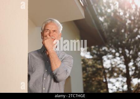 Porträt eines nachdenklichen älteren Mannes in der Nähe des Hauses draußen. Nerviger Nachbar Stockfoto