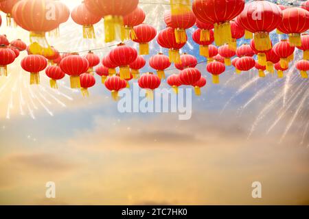 Chinesische Neujahrslaternen und Feuerwerk. Lunar Neujahrsfeier in China. Rote Papierlaterne am Sonnenunterganghimmel. Asiatische Feiertage. Party in Asien. Stockfoto