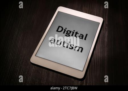 Tablette mit dem Satz Digital Autism auf Holztisch. Suchtverhalten Stockfoto