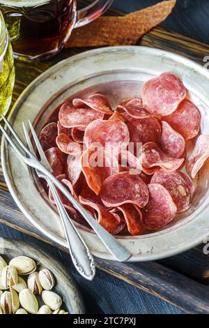 Getrocknete Schweinefleisch-Chips mit Gabeln in Vintage-Teller auf dem Tisch Stockfoto