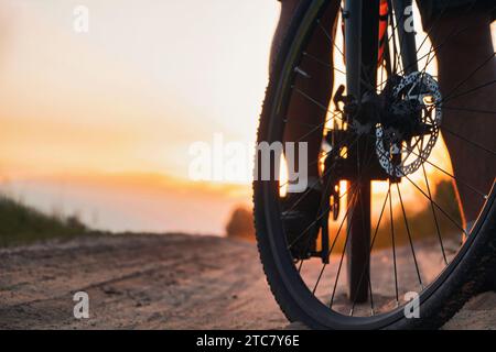 Nahaufnahme des Vorderrads auf einem Weg vor Sonnenuntergang. Radfahren im Freien. Stockfoto
