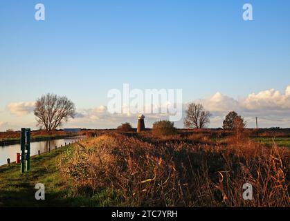 Blick auf den Deich, der zur Staithe führt, und Fußweg zur Drainage Mill an den Norfolk Broads in West Somerton, Norfolk, England, Vereinigtes Königreich. Stockfoto