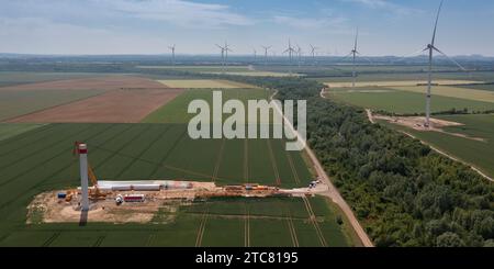 Luftaufnahme einer Windturbinenbaustelle zwischen grünen landwirtschaftlichen Feldern Stockfoto