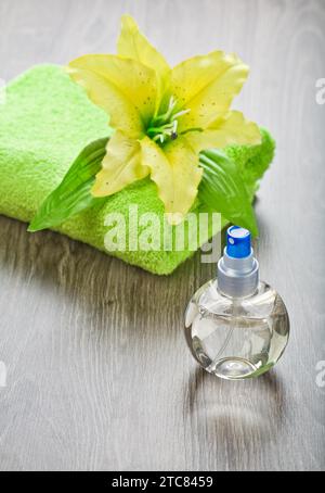 Gelbe Blume auf Handtuch und transparenter Flasche Stockfoto