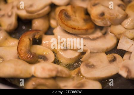 In Scheiben geschnittene Pilze in Butter braten Stockfoto