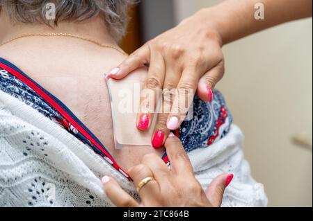 Arzt oder Krankenschwester, die medizinisches Pflaster auf ältere Frau im Krankenhaus aufbringen. Hochwertige Fotos Stockfoto