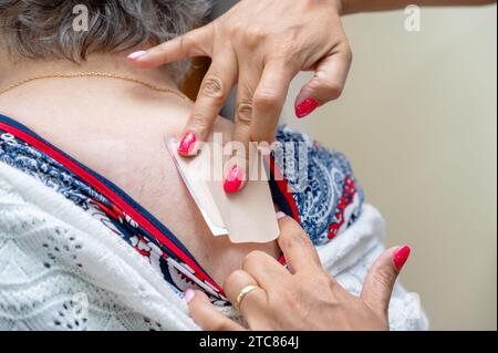 Arzt oder Krankenschwester, die medizinisches Pflaster auf ältere Frau im Krankenhaus aufbringen. Hochwertige Fotos Stockfoto