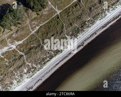 Aus der Vogelperspektive auf eine ruhige Landschaft mit einer Straße, die sich durch ein grasbewachsenes Gebiet in Varberg, Schweden, schlängelt Stockfoto