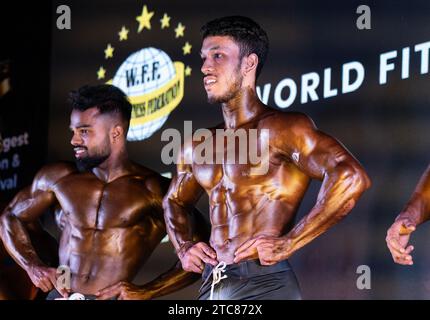 Guwahati, Assam, Indien. Dezember 2023. Bodybuilder treten am 10. Dezember 2023 bei einem regionalen Bodybuilding-Wettbewerb auf, der von der World Fitness Federation of India (WFF India) in Guwahati, Assam, Indien, organisiert wurde. Bodybuilding ist eine Sportart, die sich auf die Entwicklung und Darstellung von Muskelphysik durch eine Kombination von Widerstandstraining, Herz-Kreislauf-Training und Ernährung konzentriert. Credit: David Talukdar/Alamy Live News Credit: David Talukdar/Alamy Live News Stockfoto