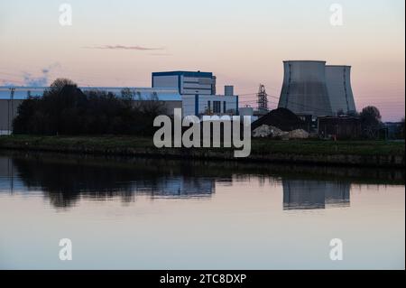 Vilvoorde, Flämische Region Brabant, Belgien, 28. November 2023 - Industriekraftwerk reflektiert im Wasser des Kanals in der Abenddämmerung Stockfoto