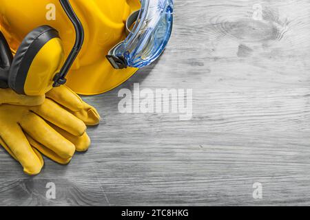 Kapselgehörschützer Schutzbrille Handschuhe Schutzhelm auf Holzbrett Konstruktionskonzept Stockfoto