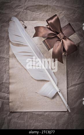 Präsentieren Sie ein Blatt mit Geschenkpapier-Federn-Feiertagskonzept Stockfoto