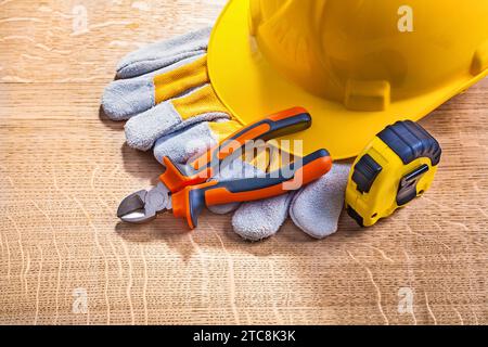 Helmhandschuhe Zangen Tapeline auf Holzbrett Stockfoto