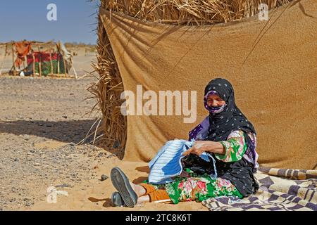 Ältere nomadische Beduinenfrau mit Hijab-Wollkleid in der Sahara bei Merzouga, Drâa-Tafilalet, Errachidia, Marokko Stockfoto