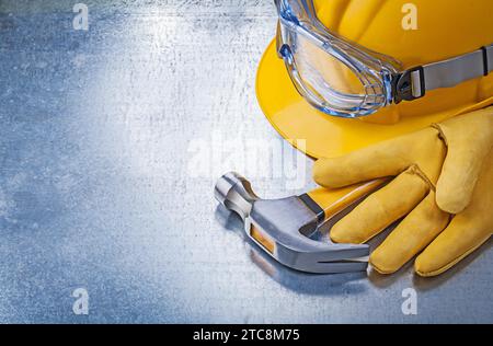 Schutzbrille Handschuhe Bauhelm Klauenhammer auf metallischem Hintergrund Stockfoto