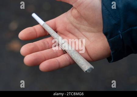 Rotterdam, Niederlande - 5. Dezember 2023: Ein Mann hält einen Cannabis Joint in der Hand *** ein Mann hält einen Cannabis Joint in der Hand Credit: Imago/Alamy Live News Stockfoto