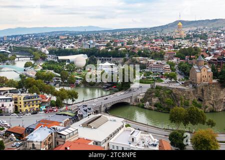 Tiflis, Georgien - 23. September 2023: Blick über Tiflis Stadt mit Metekhi und Rike Park von der Festung Narikala am bewölkten Herbstabend Stockfoto