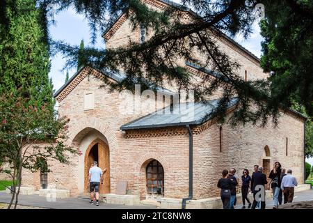 Bodbe, Georgien - 24. September 2023: Touristen in der Nähe der alten Kirche St. George mit dem Grab des Heiligen Nino im Bodbe Kloster in der Region Kakheti von Georgien auf sunn Stockfoto