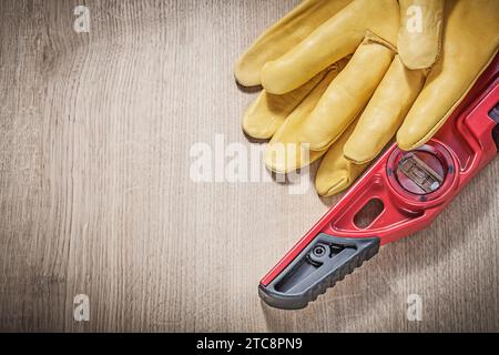 Leder-Sicherheitshandschuhe, Bauhöhe auf Holzbrett Stockfoto