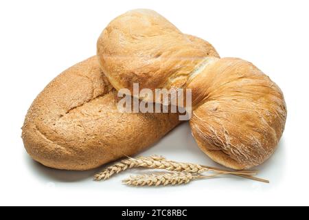 Zwei Brotlaibe und Weizenohren vor weißem Hintergrund Stockfoto