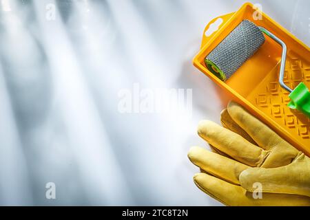 Gelbe Sicherheitshandschuhe Lack Tablett Rolle auf weißem Hintergrund Stockfoto