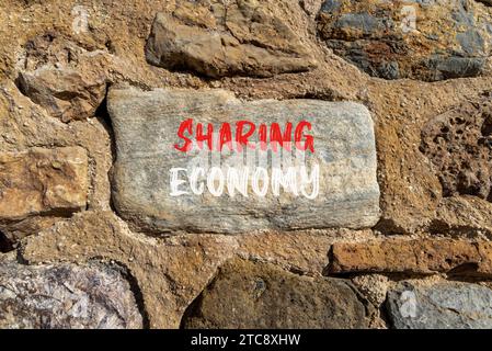 Symbol für geteilte Wirtschaft. Konzeptworte teilen die Wirtschaft auf wunderschönem grauem Stein. Schöner brauner Steinmauerhintergrund. Business Sharing Economy-Konzept Stockfoto