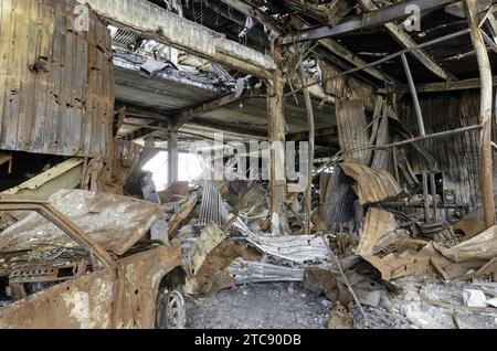Verbrannter militärischer Panzerwagen auf der Straße des zerstörten Stadtkrieges Ukraine Russland Stockfoto