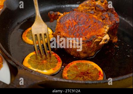 Schweinekotelett auf einer eisernen Pfanne mit Zitronen- und Gewürzwürzen gebraten Stockfoto