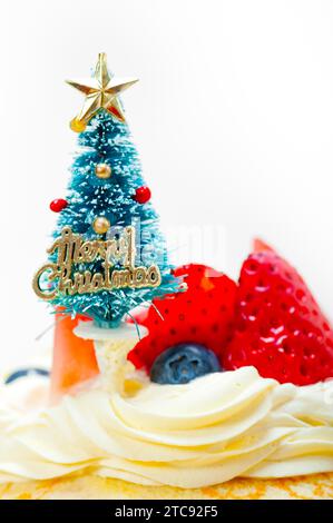 Weihnachtsbaum auf einem Pfannkuchenkrepé-Berg mit Schlagsahne und Erdbeere Stockfoto