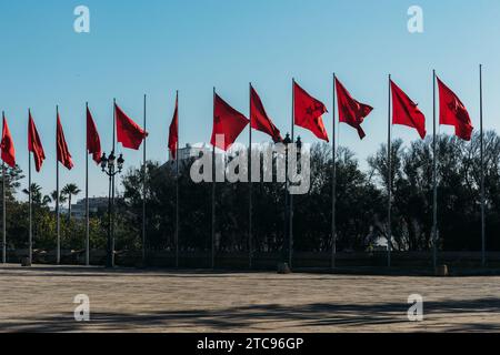 Marokko-Zeichen-Symbol. Marokkanische Staatsflagge auf Flaggenmast, winkend im Wind, blauer Hintergrund Stockfoto