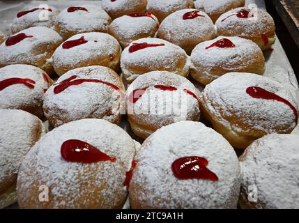 Jerusalem, Israel. Dezember 2023. Ein Blick auf Sufganiyot, einen frittierten, mit Gelee gefüllten Donut, in der fünften Nacht des jüdischen Feiertags von Hanukka, dem Festival der Lichter, auf dem Mahane Yehuda Markt in Jerusalem, am Montag, 11. Dezember 2023. Der achttägige Hanukka-Feiertag erinnert an den Sieg der Makkabäer über das griechisch-syrische Königreich und die Wiedereinweihung des Zweiten Tempels. Foto: Debbie Hill/ Credit: UPI/Alamy Live News Stockfoto