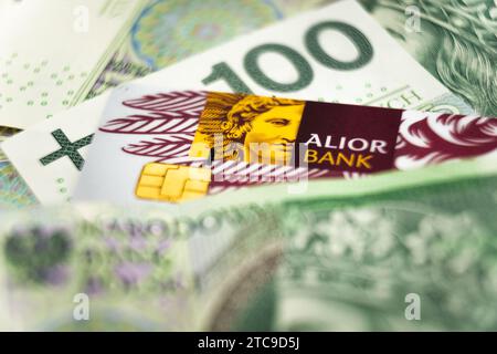 Wałbrzych, polen - 11.12.2023: Alior-Banklogo auf einer Kreditkarte unter polnischen Zloty-Banknoten Stockfoto