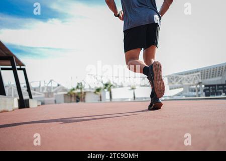 Rückansicht der Beine eines nicht wiedererkennbaren Sportmannes, der schnell läuft und das Herz mit Agilität trainiert. Nahaufnahme eines männlichen Fußes bei einem Workout. Foto von einem sportlichen Kerl, der eine Fitness-Speed-Routine macht. Hochwertige Fotos Stockfoto