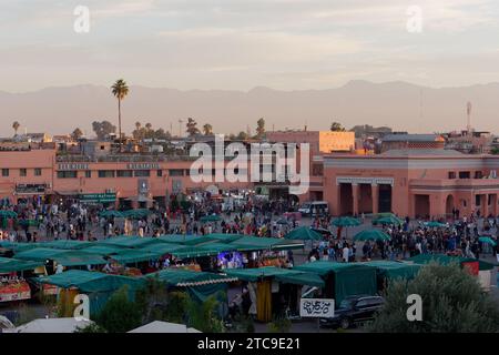 Blick auf den Platz Jemaa el-Fna am Abend bei Sonnenuntergang mit den Bergen dahinter. Marrakesch aka Marrakesch, Marokko, 11. Dezember 2023 Stockfoto