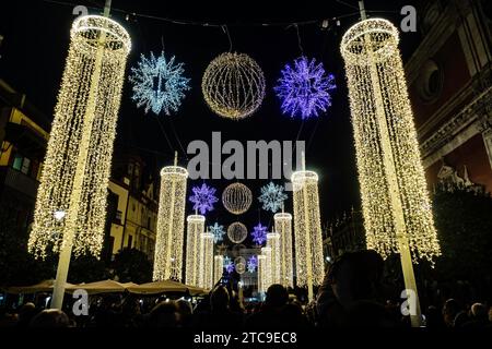 Elegante Holiday Light Säulen und Schneeflocken, majestätische Säulen aus Weihnachtslichtern und glitzernde Schneeflocken funkeln in der Nacht. In Sevilla, Spanien. Stockfoto